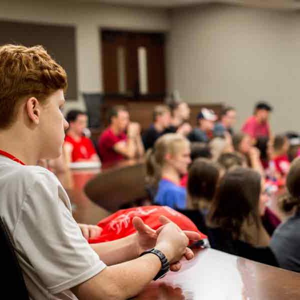 BCYC participants listen to a presentation in an auditorium