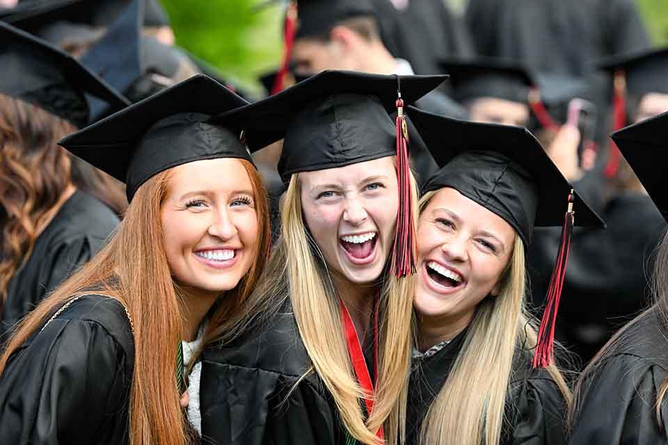 Graduates pose for a photo in cap and gown